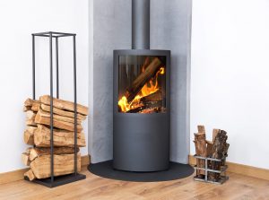 Modern burning stove next to a wood logs rack.